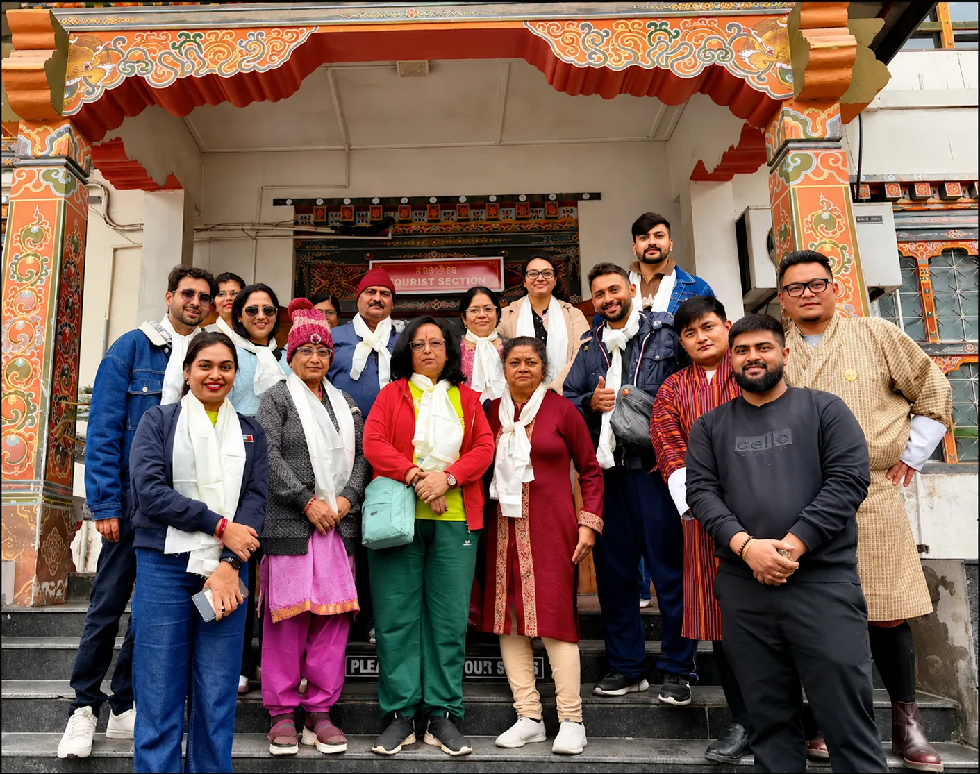 Cross Over Holidays guests on a Bhutan tour, photographed with khadar scarves outside the tourist permit office in Phuentsholing